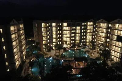 a view of a hotel at night with a pool at Studio Apartment by the Sea E413 in Phuket Town