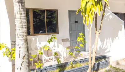 a white house with a chair and a window at The coconut nanai resort in Patong Beach