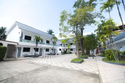 an empty courtyard in front of a building with palm trees at The coconut nanai resort in Patong Beach