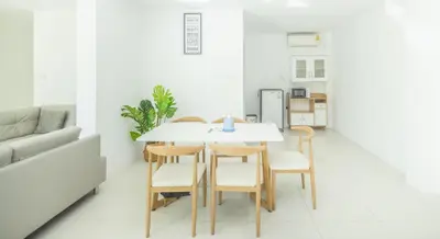 a dining room with a white table and chairs at The coconut nanai resort in Patong Beach