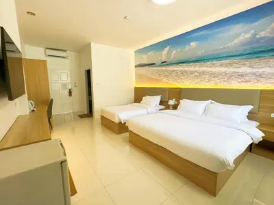 a bedroom with two beds and a painting of the beach at The coconut nanai resort in Patong Beach