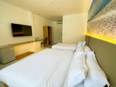 a hotel room with two beds and a television at The coconut nanai resort in Patong Beach