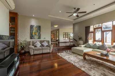 a living room with two couches and a ceiling fan at Villa Moon Talay View in Patong Beach