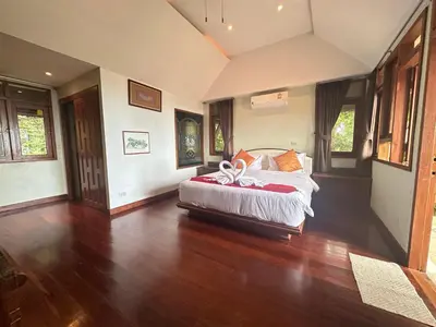 a bedroom with a bed in a room with wooden floors at Villa Moon Talay View in Patong Beach