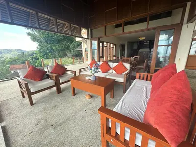 a room with couches and chairs and a table at Villa Moon Talay View in Patong Beach