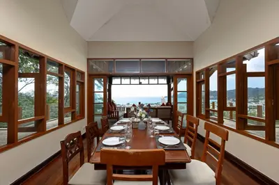a dining room with a long table and chairs at Villa Moon Talay View in Patong Beach