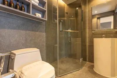 a bathroom with a toilet and a glass shower at C141 Fully Loaded Best Facilities Nicest Apartment in Kamala Beach