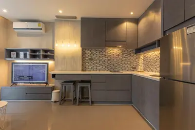 a kitchen with grey cabinets and a tv in it at C141 Fully Loaded Best Facilities Nicest Apartment in Kamala Beach