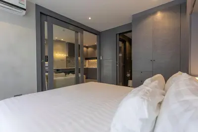 a bedroom with a large white bed with glass walls at C141 Fully Loaded Best Facilities Nicest Apartment in Kamala Beach