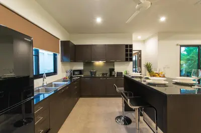 a kitchen with a large island with a counter top at Tropical 3BR Pool Villa Nga Chang NC10, Gated Residence, 10 min Drive to Nai Harn Beach in Rawai Beach