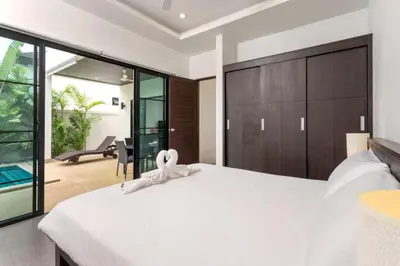 a bedroom with a large white bed with a white ribbon at Tropical 3BR Pool Villa Nga Chang NC10, Gated Residence, 10 min Drive to Nai Harn Beach in Rawai Beach