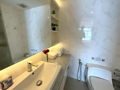 a bathroom with a sink and a toilet and a mirror at Sea view apartment at Aristo2 by Lofty in Surin Beach
