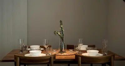 a wooden table with plates and glasses and a vase at The Title Halo 1 Apartment 10 min to Nai Yang Beach in Nai Yang Beach