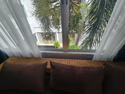 a window with a couch in front of it with pillows at Andaman homestay villa at rawai in Ban Saiyuan (1)