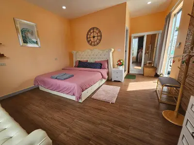 a bedroom with a bed and a chair in it at Andaman homestay villa at rawai in Ban Saiyuan (1)