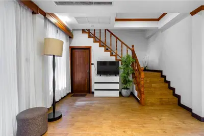 a living room with a staircase and a television at Private Villas Bangtao in Bang Tao Beach