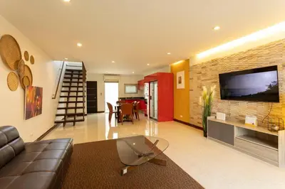 a living room with a couch and a television on a wall at 12 minutes Patong Security Gym Sauna AP12 #V28 in Kamala Beach