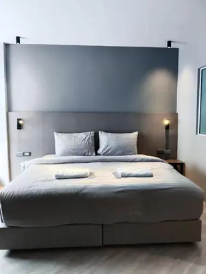 a bedroom with a large bed with two towels on it at Doze Patong in Patong Beach