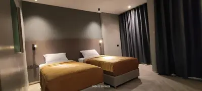 a hotel room with two beds and a window at Doze Patong in Patong Beach