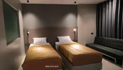 a small room with two beds and a couch at Doze Patong in Patong Beach