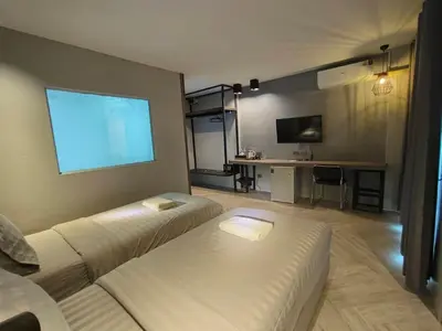 a living room with a couch and a flat screen tv at Doze Patong in Patong Beach