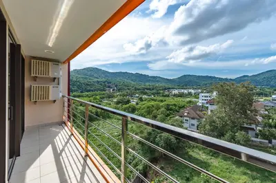 a balcony with a view of the mountains at Уютные апартаменты NBC Nai Harn in Rawai Beach