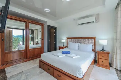 a bedroom with a large bed and a window at Уютные апартаменты NBC Nai Harn in Rawai Beach