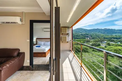 a bedroom with a bed and a balcony at Уютные апартаменты NBC Nai Harn in Rawai Beach