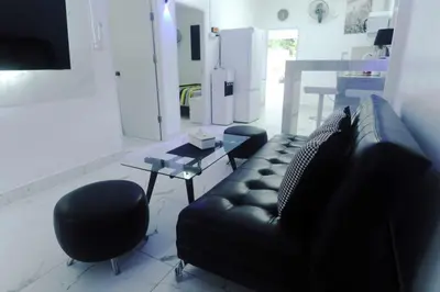 a living room with a black leather couch and a table at Prestige Pool Villa by Karon Homes in Karon Beach