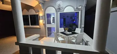 a balcony with a table and chairs in a room at Prestige Pool Villa by Karon Homes in Karon Beach