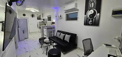 a living room with a black couch and a table at Prestige Pool Villa by Karon Homes in Karon Beach