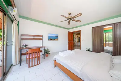 a bedroom with a bed and a desk at Unique Style 3BR Apartment BGV 216 in Gated Residence, Kata in Kata Beach