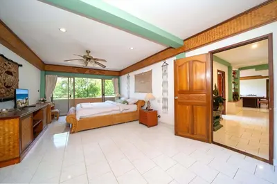 a bedroom with a bed and a sliding glass door at Unique Style 3BR Apartment BGV 216 in Gated Residence, Kata in Kata Beach