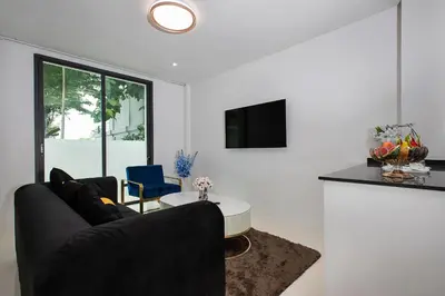 a living room with a couch and a table at Nariya Bayfront Phuket in Chalong