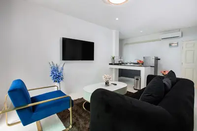 a living room with a couch and a blue chair at Nariya Bayfront Phuket in Chalong