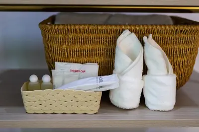 a basket with a pair of white shoes and cosmetics at Nariya Bayfront Phuket in Chalong
