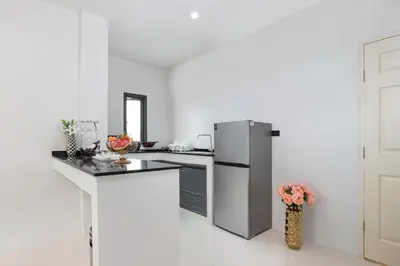 a kitchen with a refrigerator and a counter top at Nariya Bayfront Phuket in Chalong