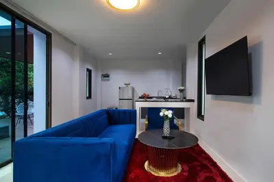 a living room with a blue couch and a table at Nariya Bayfront Phuket in Chalong