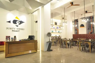 a dining room with tables and chairs in a restaurant at Forty Winks Phuket Hotel in Patong Beach