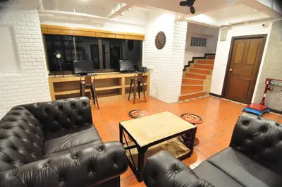 a living room with a leather couch and a table at Forty Winks Phuket Hotel in Patong Beach