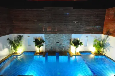 a swimming pool with blue lights in a building at Forty Winks Phuket Hotel in Patong Beach