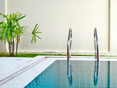 a swimming pool with two metal railings in a house at Krabi Private Pool Villa 1 by Belcarrra Spaces in Ban Khlong Haeng