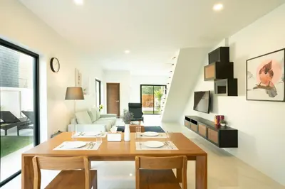 a dining room and living room with a wooden table at Krabi Private Pool Villa 1 by Belcarrra Spaces in Ban Khlong Haeng