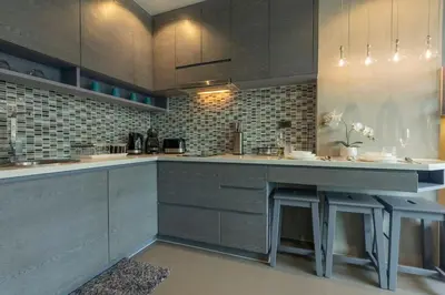 a kitchen with gray cabinets and a counter with benches at Nicest Condo in City gate Kamala 6km Patong #c118 in Kamala Beach