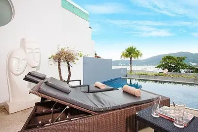a patio with a bed and a swimming pool at Atika Villas in Patong Beach