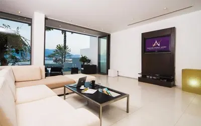 a living room with a couch and a tv at Atika Villas in Patong Beach