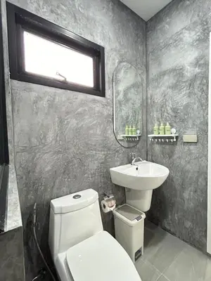 a bathroom with a white toilet and a sink at JK Studio, Koh Yao Noi in Ko Yao Noi