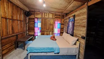 a bedroom with a bed in a wooden cabin at Big Hug Home - Sa med kaw in Ban Takhrai