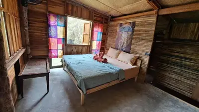 a woman laying on a bed in a room with stained glass windows at Big Hug Home - Sa med kaw in Ban Takhrai