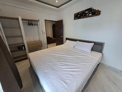 a bedroom with a bed with white sheets and a ladder at Yuya's sweet Condo suite in Patong Beach